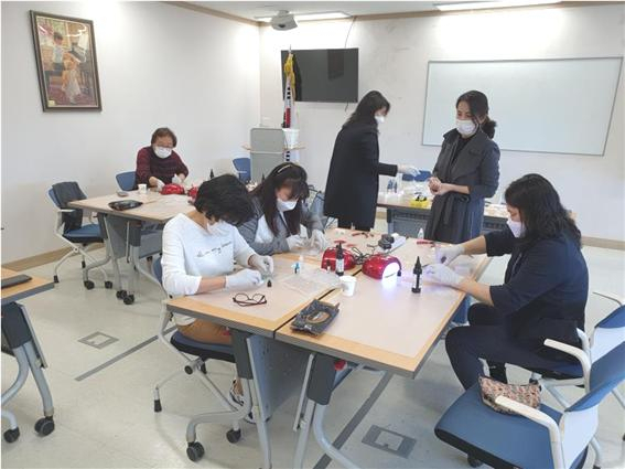 행정안전부 지정 신규 마을기업으로 선정된 디디엠 메이커 협동조합에서 레진공예 봉사가 진행 중인 모습.[동대문구 제공]