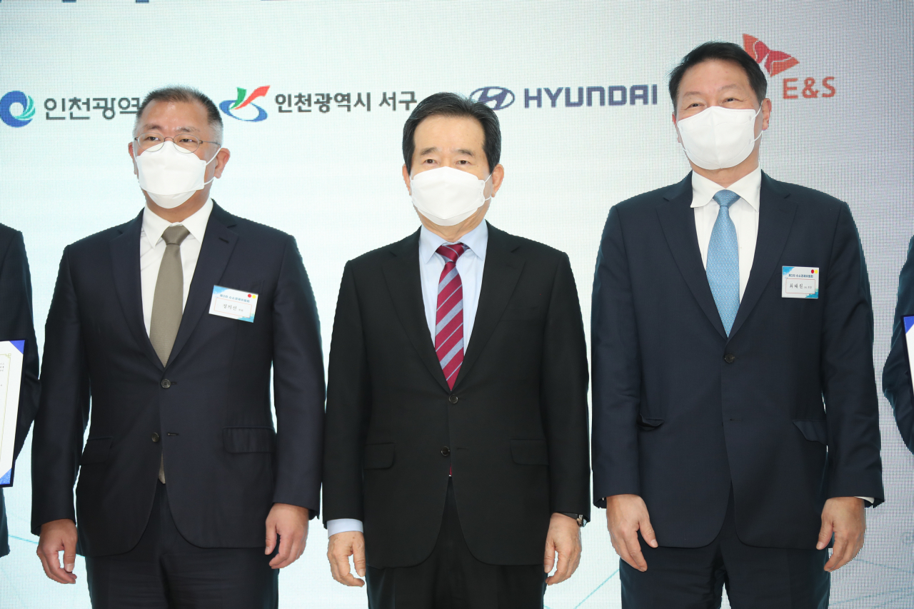 정세균 국무총리( 가운데)가 2일 SK인천석유화학에서 열린 수소산업 생태계 구축 선포식에서 정의선 현대차그룹 회장(왼쪽), 최태원 SK그룹 회장(왼쪽)과 기념촬영을 하고 있다. [연합]