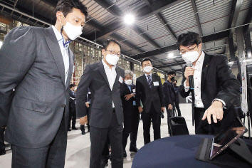 구현모(왼쪽 두번째) KT 대표, 정기선(왼쪽 첫번째) 현대중공업지주 부사장 등이 로봇물류시스템 데모센터에서 5G 기반 AI 무인지게차에 대한 설명을 듣고 있다. [KT 제공]
