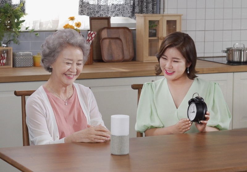 SKT는 지난해 시니어 건강 등을 챙겨주는 서비스 ‘누구 오팔’을 출시했다. 가수 송가인(오른쪽)이 어르신에게 사용법을 안내하고 있다. [SKT 제공]