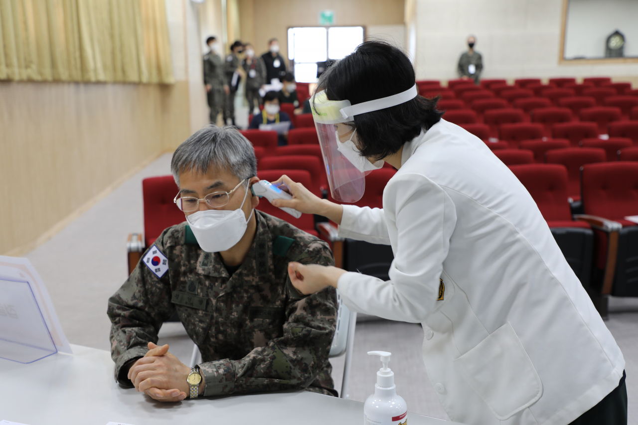 국방부는 3일부터 16개 군 병원을 시작으로 군내 코로나19 예방접종이 시행된다고 밝혔다. 김인영(왼쪽) 국군양주병원장(대령)이 우경인 진료 2부장(중령)으로부터 예방접종을 받고 있다. [국방부 제공]