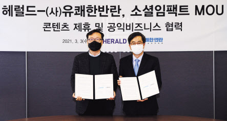 권충원(왼쪽) 헤럴드 대표이사와 김동연 유쾌한반란 이사장이 ‘소셜임팩트 MOU’를 체결한뒤 협약서를 들어보이고 있다. 박해묵 기자
