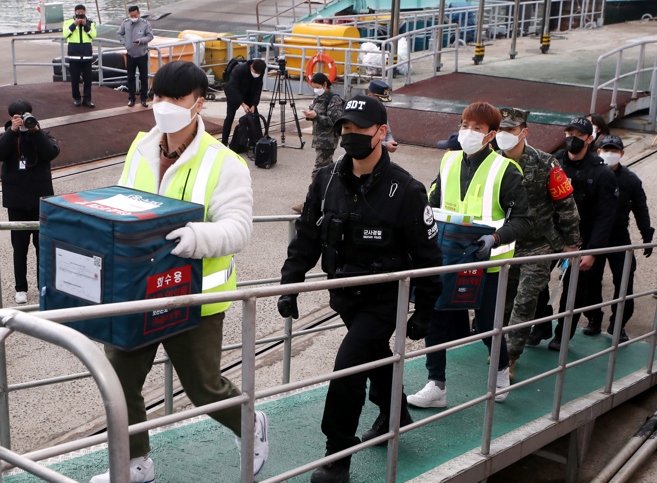4일 오전 인천시 중구 인천항 연안여객터미널에서 방역 당국 관계자들이 신종 코로나바이러스 감염증(코로나19) 백신 보관함을 들고 백령도행 여객선에 승선하고 있다. [연합]