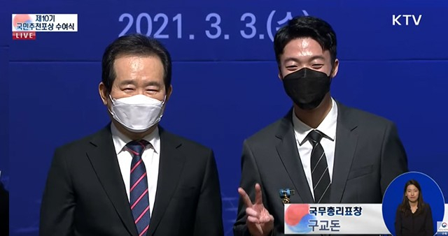 11층 주상복합건물 화재를 목격하고 인명피해 없이 200여 명을 대피시킨 23살 용감한 청년 구교돈 씨(오른쪽)가 국무총리 표창을 수상한 후 정세균 국무총리(왼쪽)와 기념촬영을 하고 있다. [행안부]