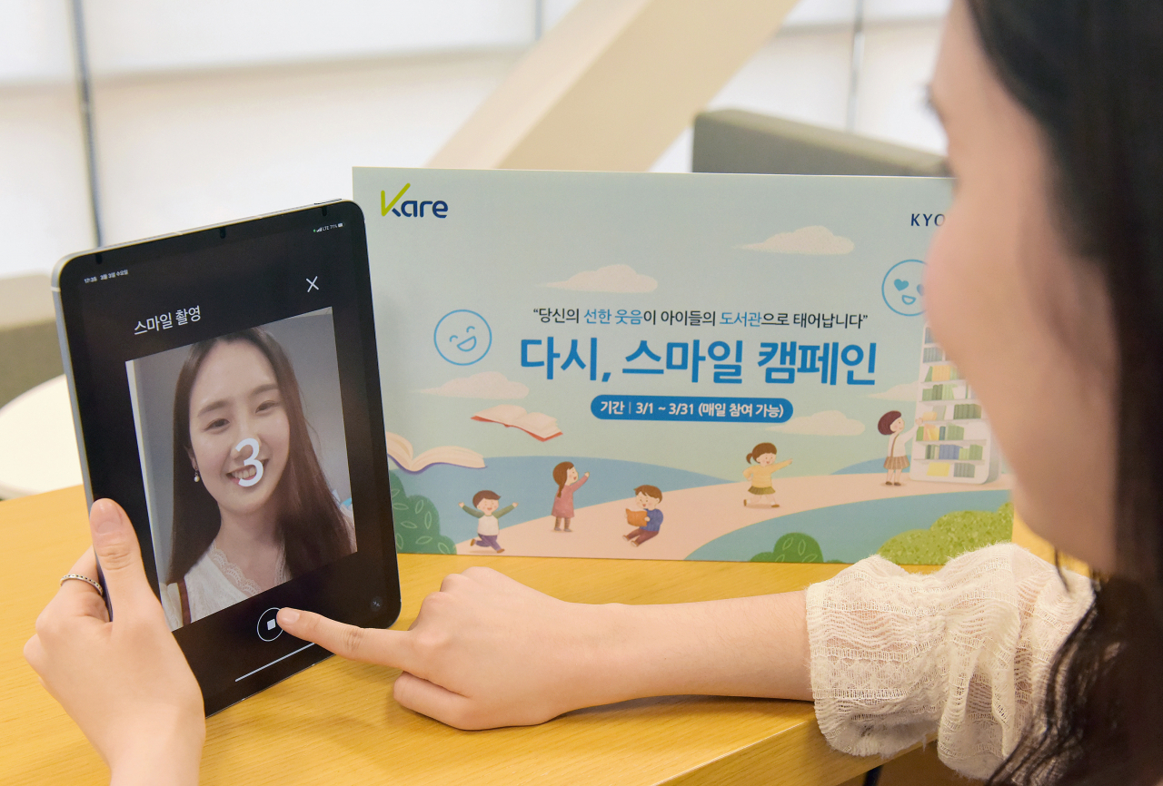 교보생명이 새봄을 맞아 3월 한 달간 AI 카메라로 웃음지수를 측정한 '스마일 기부'를 통해 소외계층 어린이들에게 책을 선사하는 '다시, 스마일' 캠페인을 펼친다. 사진은 4일 '다시, 스마일' 캠페인에 참여한 교보생명 직원이 스마일 카메라로 웃는 모습을 촬영하는 모습. [교보생명 제공]