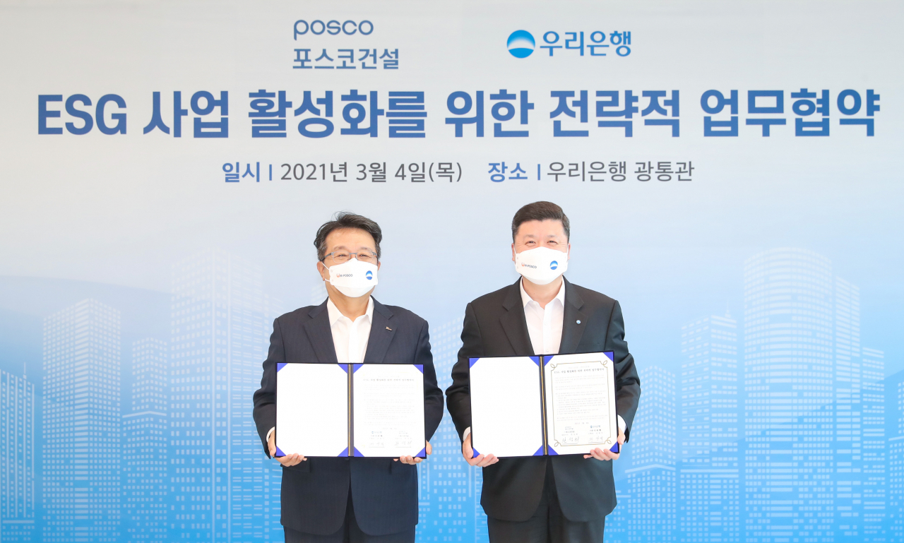 권광석 우리은행장(오른쪽)과 한성희 ㈜포스코건설 대표가 4일 서울 중구 우리은행 본점 광통관에서 'ESG 사업 활성화를 위한 전략적 업무협약'을 맺은 뒤 기념촬영을 하고 있다. [우리은행 제공. 재판매 및 DB 금지]