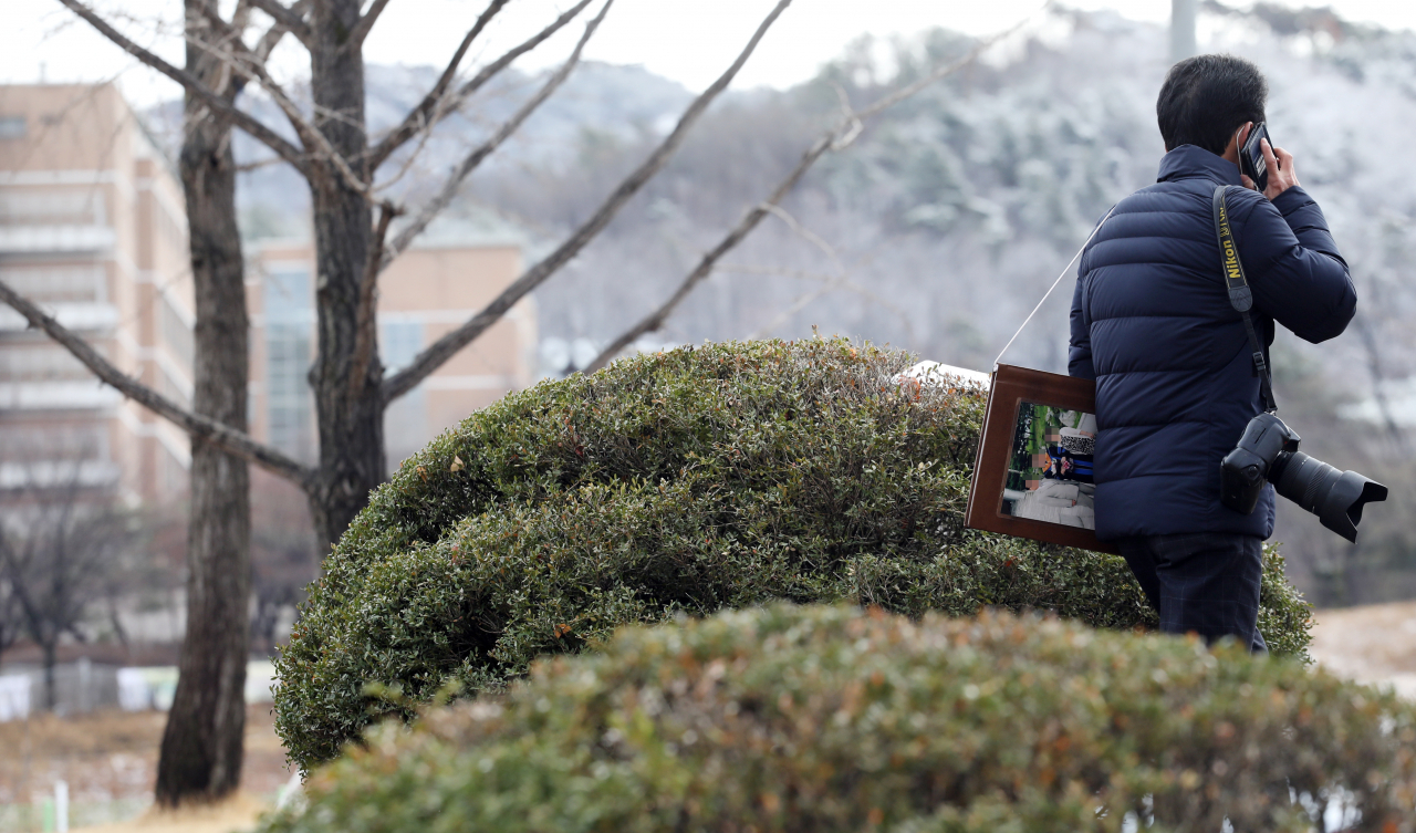 지난 2일 서울 관악구 서울대 정문에서 한 사진사가 통화를 하고 있다. 신종 코로나바이러스 감염증(코로나19) 탓에 같은 날 서울대는 입학식을 비대면 방식으로 치렀다. 때문에 학교를 찾는 신입생은 드물었다. [연합]