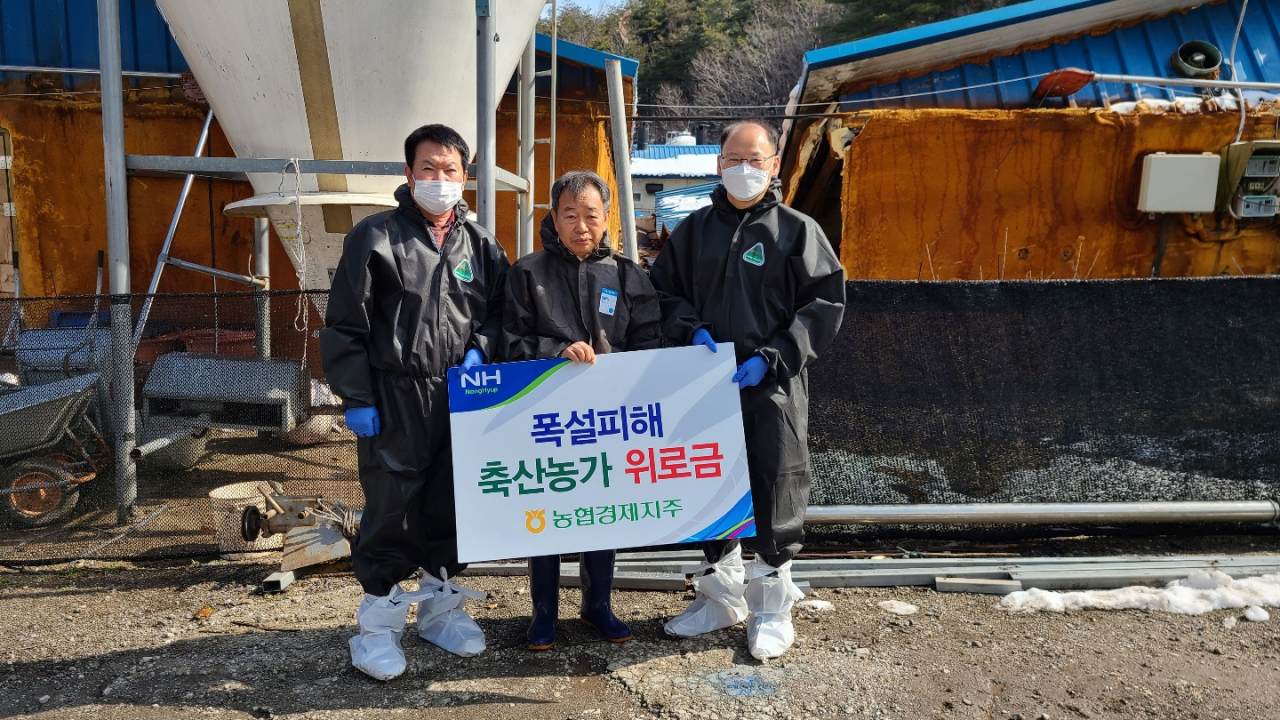 김태환(오른쪽) 농협축산경제대표가 7일 강원지역 폭설 피해 농가를 방문해 위로금을 전달한 후 기념촬영을 하고 있다.［헤럴드DB］