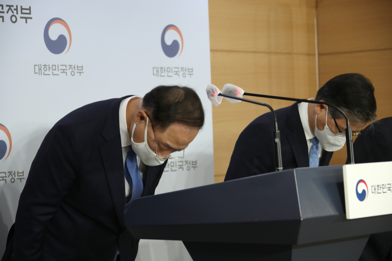 Finance Minister and Deputy Prime Minister Hong Nam-ki (left) bows his head in apology over the latest scandal involving alleged speculative purchases of land lots by officials at the Korea Land & Housing Corp., following a meeting of real estate policy-related ministers held at the Seoul government complex on Sunday. (Yonhap)