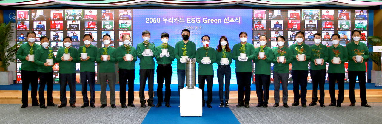 5일 우리카드 광화문 본사에서 열린 '2050 우리카드 ESG Green 선포식'에서 김정기 사장(왼쪽 열번째) 및 임직원들이 플라스틱 폐기물로 만든 화분을 들고 기념사진을 촬영하고 있다.[우리카드 제공]
