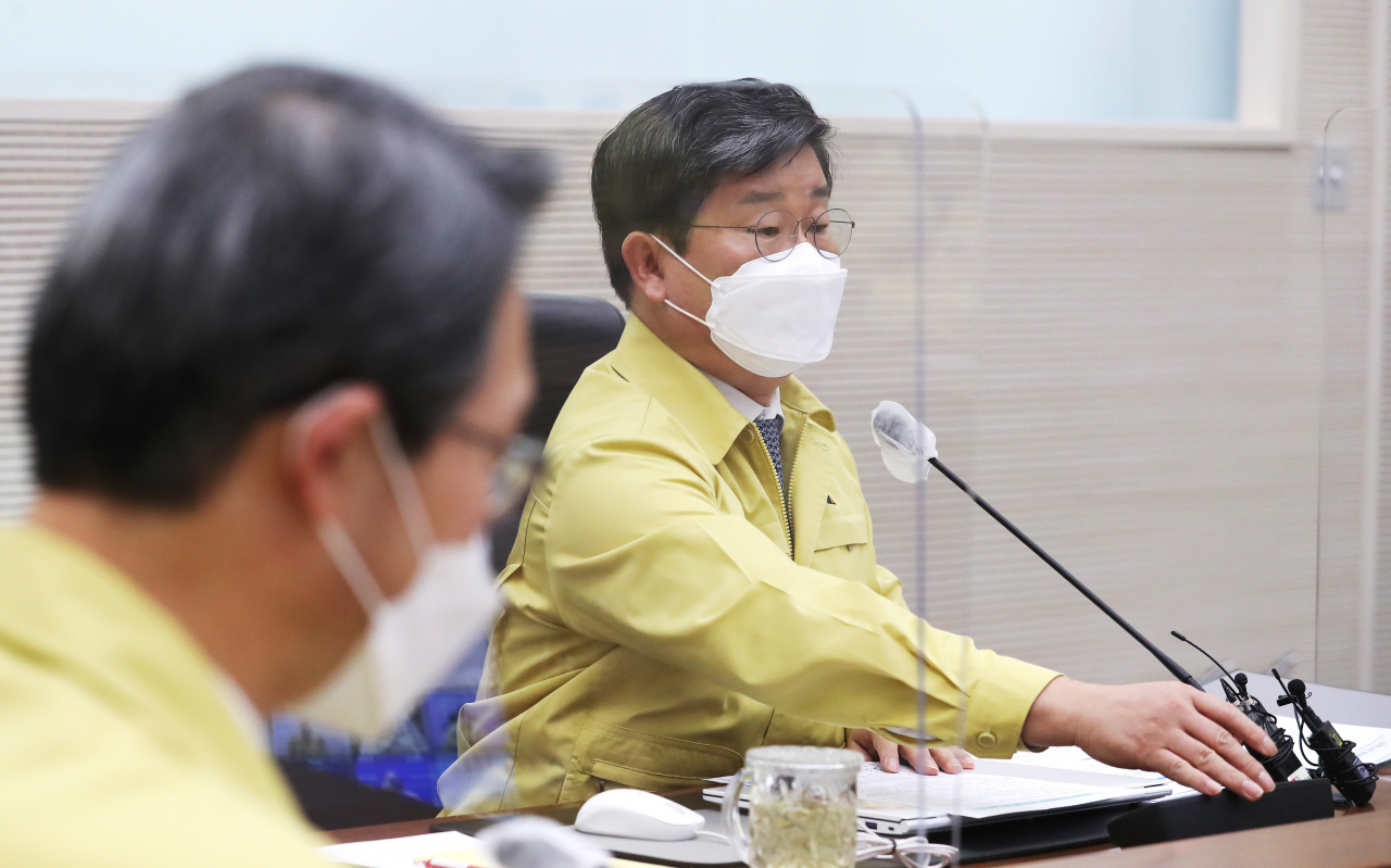 전해철 행정안전부 장관(오른쪽)이 8일 오전 세종시 정부세종 2청사에서 열린 신종 코로나바이러스 감염증(코로나19) 대응 중앙재난안전대책본부 회의에서 발언하기 위해 마이크를 조정하고 있다. [연합]