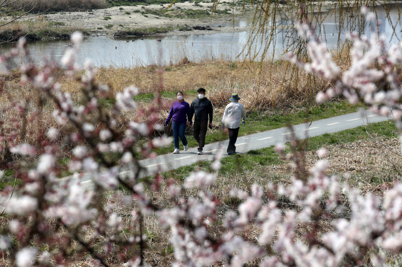 The photo shows people in face masks at a park in Gwangju on Tuesday afternoon. (Yonhap)