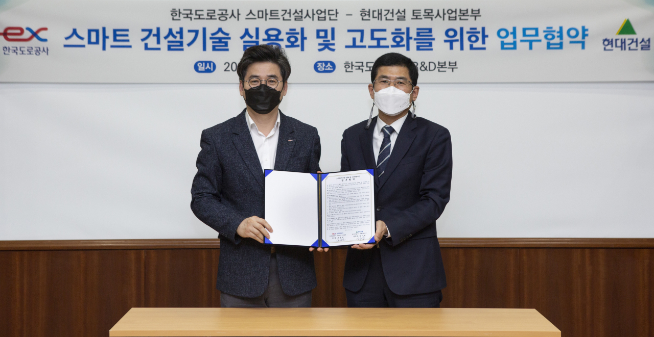 스마트건설기술 실용화 및 고도화를 위한 업무협약(MOU) 체결 사진. 왼쪽부터 조성민 한국도로공사 스마트건설사업단장, 김기범 현대건설 토목사업본부장. [현대건설 제공]