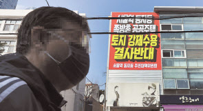 서울 용산구 동자동 쪽방촌 일대 건물 외벽에 걸린 공공주택 토지 강제수용 결사반대 현수막. [연합]