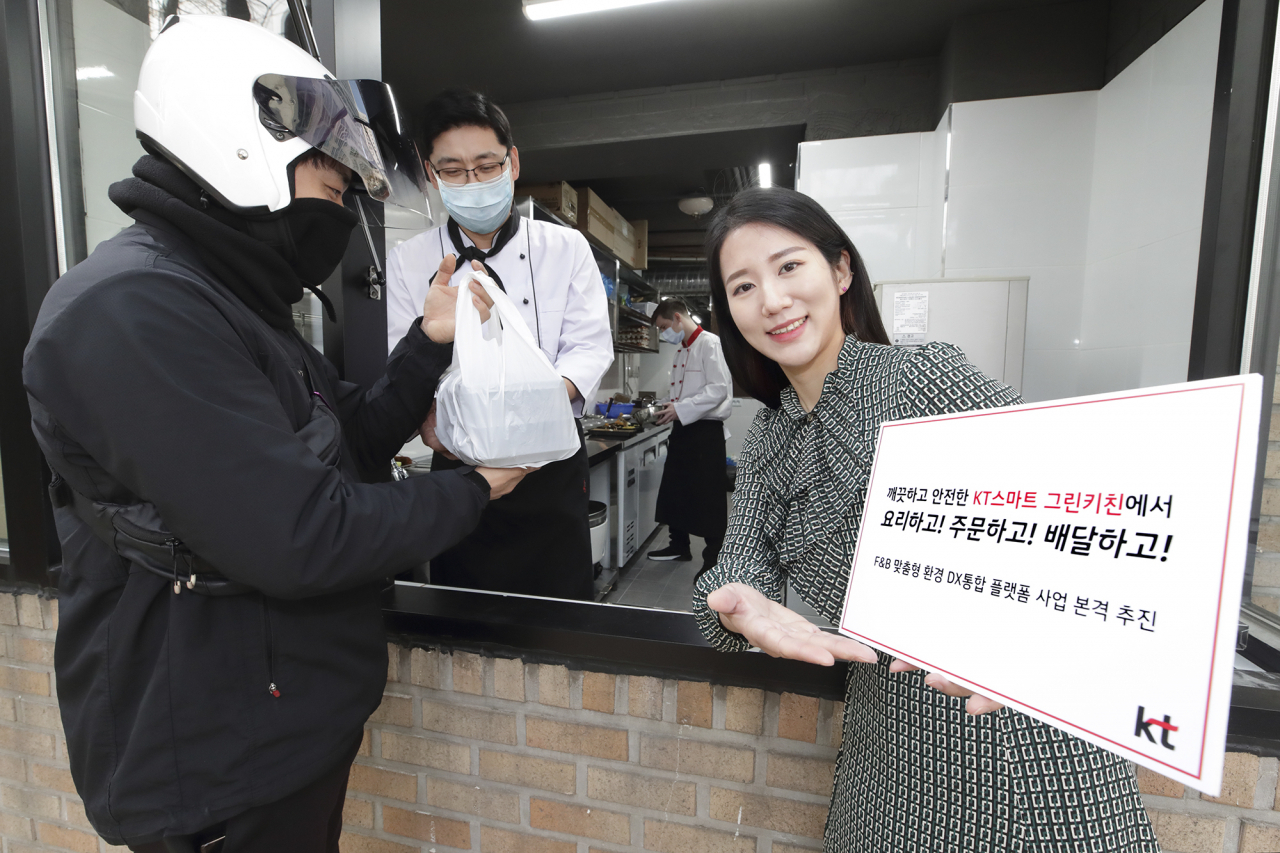 KT 스마트 그린키친을 통해 조리된 음식을 배달원이 받고 있다. [KT 제공]