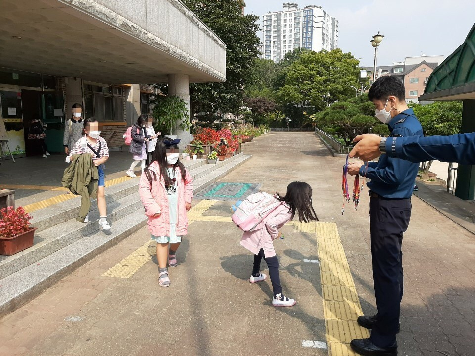 학교전담경찰관(SPO)으로 활동 중인 이은택 경기 안양동안서 경사가 최근 한 초등학교에서 학생들에게 마스크 스트랩을 나눠주는 모습. [이은택 경사 제공]