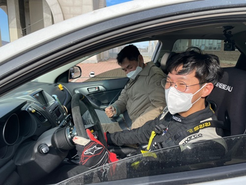 전남과학대학교 교수들이 모터스포츠 설명회장을 찾아 차량에 탑승하고 있다.