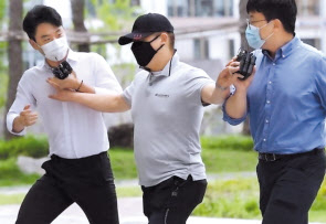 구급차를 막아 이송 중인 환자를 숨지게 한 혐의를 받는 택시기사 최모(가운데) 씨가 지난해 7월 서울동부지법에서 열린 영장실질심사에 출석하고 있는 모습. [연합]