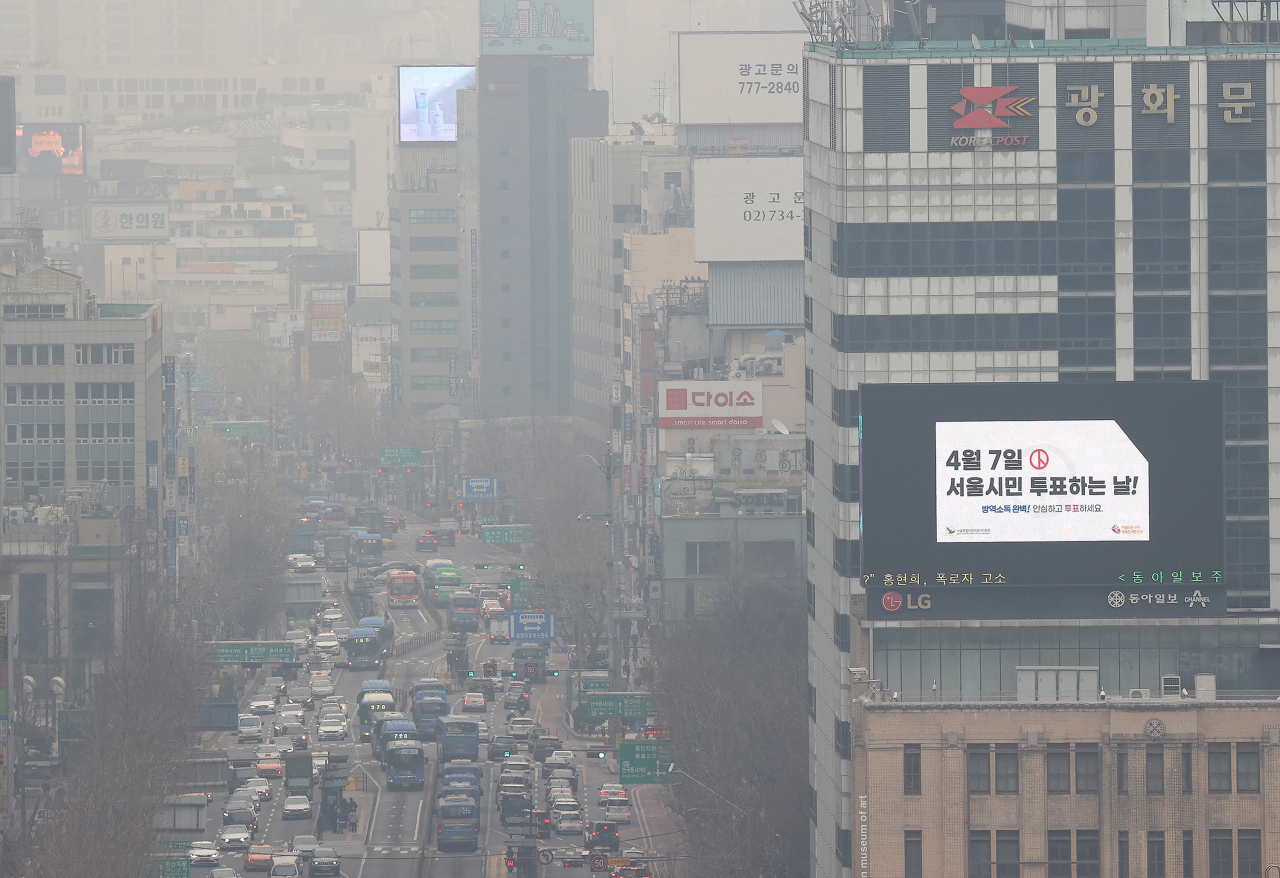 서울, 인천, 경기 등 수도권 지역에서 미세먼지 비상저감조치가 이틀 연속 시행된 12일 오전 서울 종로구 서울시교육청에서 바라본 도심. 희뿌연 대기 속 4·7 서울시장 보궐선거 홍보 영상이 전광판에 나오고 있다. [연합]