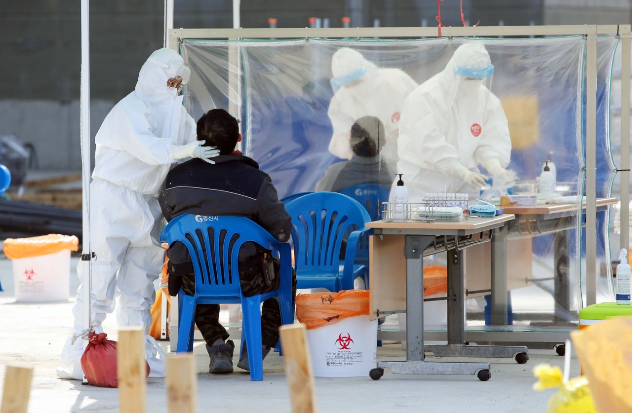 Foreign workers are tested for COVID-19 on Thursday at a temporary diagnostics center installed near a construction site in Gyeongsan, North Gyeongsang Province. (Yonhap)