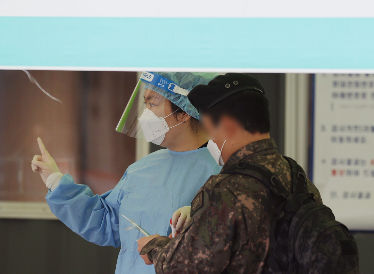 12일 서울역 광장 임시 선별검사소에서 한 군인이 코로나19 검사를 받기 위해 안내를 받고 있다. 중앙방역대책본부는 이날 0시 기준으로 코로나19 신규 확진자가 488명 늘어 누적 9만4686명이라고 밝혔다. 하루 확진자 488명은 지난달 19일(561명) 이후 21일 만에 가장 많은 수치다. [연합]