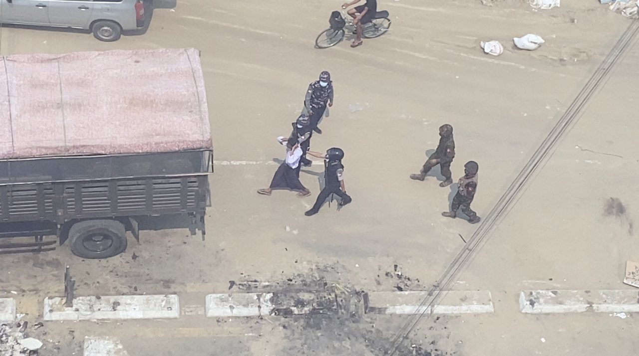 미얀마 경찰들이 12일(현지시간) 미얀마 최대 도시 양곤에서 군부 쿠데타에 저항하는 시민들을 체포하고 있다.[로이터]