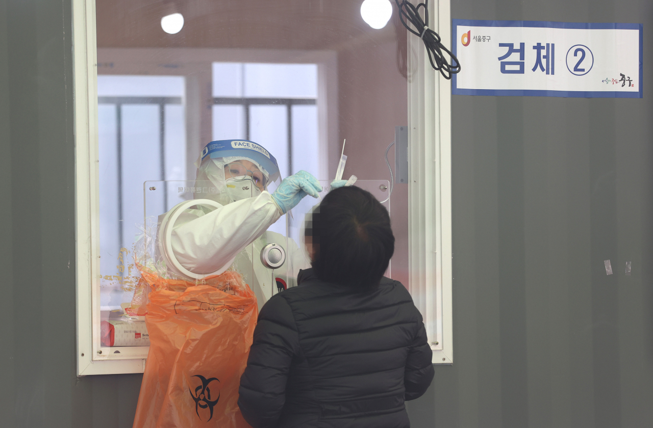 13일 오전 서울역광장에 마련된 임시선별진료소에서 의료진이 검체를 채취하고 있다. [연합]