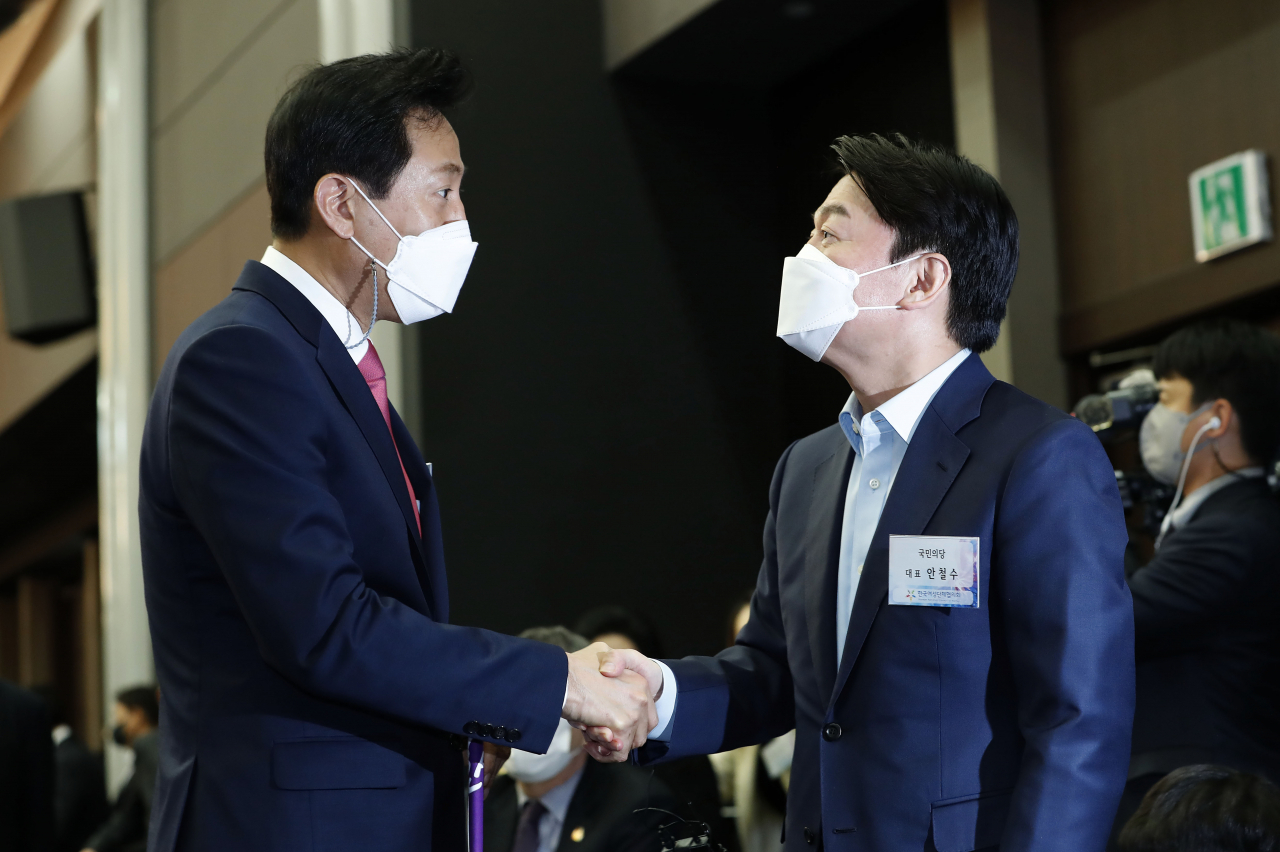 오세훈 국민의힘 서울시장 후보(왼쪽)와 안철수 국민의당 서울시장 후보가 8일 오후 서울 영등포구 공군호텔에서 열린 제113주년 3·8 세계 여성의 날 기념식에서 악수하고 있다. [연합]