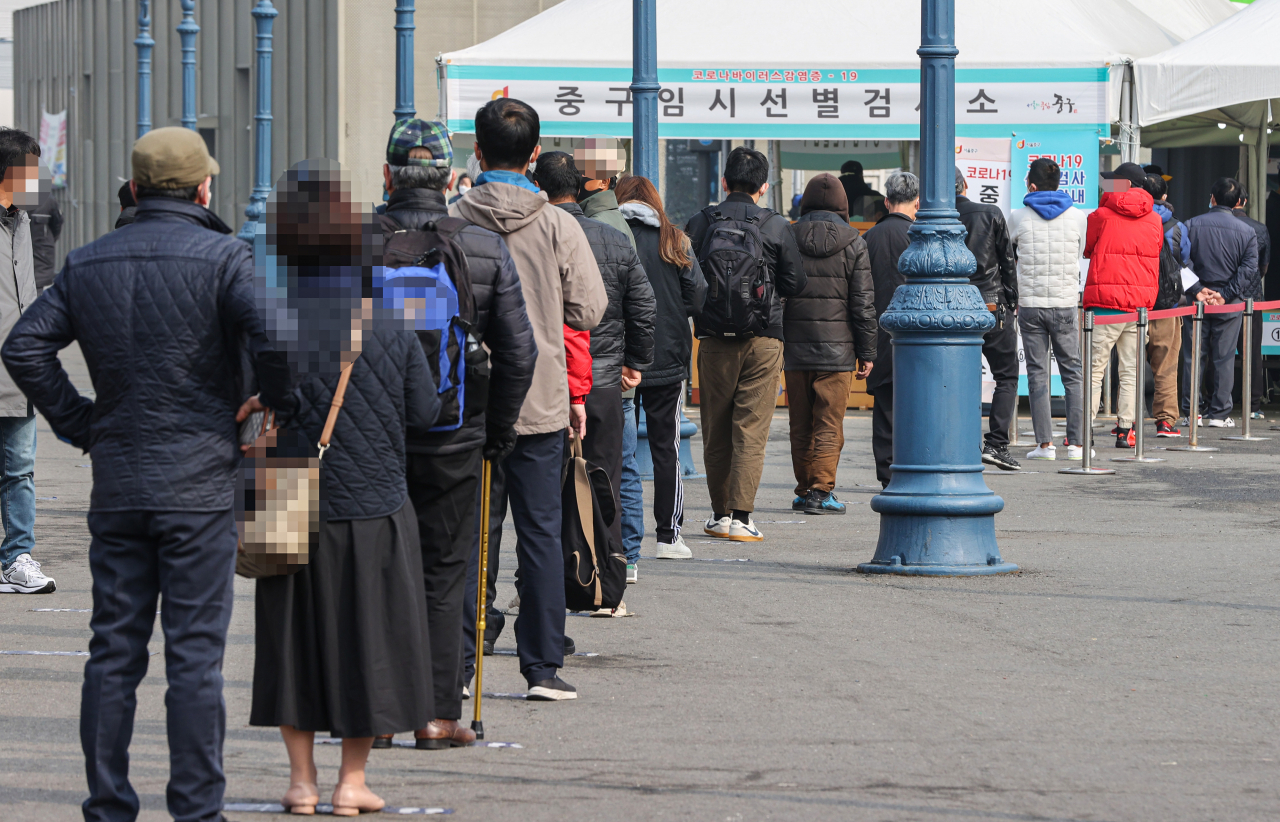신종 코로나바이러스 감염증(코로나19) 신규 확진자가 엿새 연속 400명대를 기록한 14일 오전 서울 중구 서울역 광장에 설치된 임시선별검사소가 시민과 국내 거주 외국인으로 붐비고 있다. [연합]