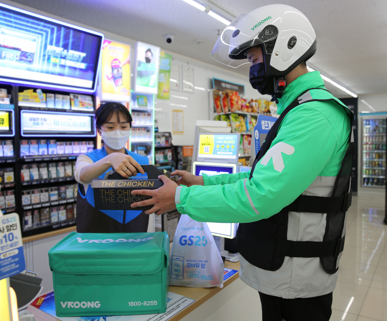 GS25 직원이 부릉 라이더에게 쏜살치킨과 제품을 건네고 있다 [사진제공=GS25]