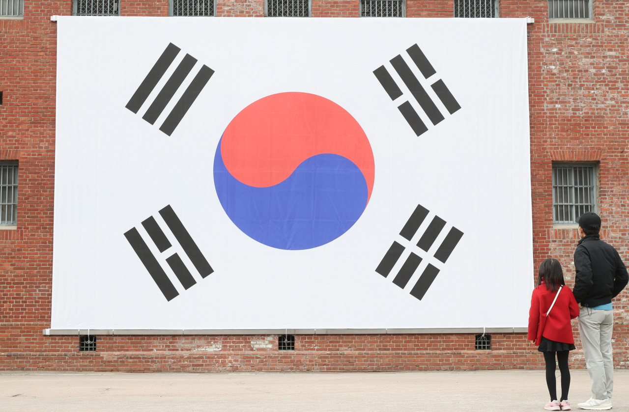 미얀마인들의 중국에 대한 반감이 높아지고 있는 가운데 미얀마 소재 한국인 공장에 태극기를 걸어 중국인 공장과 차별화할 계획이다. 사진은 삼일절을 맞아 서울 서대문구 서대문형무소역사관에 걸린 대형 태극기를 시민들이 바라보는 모습.[연합]