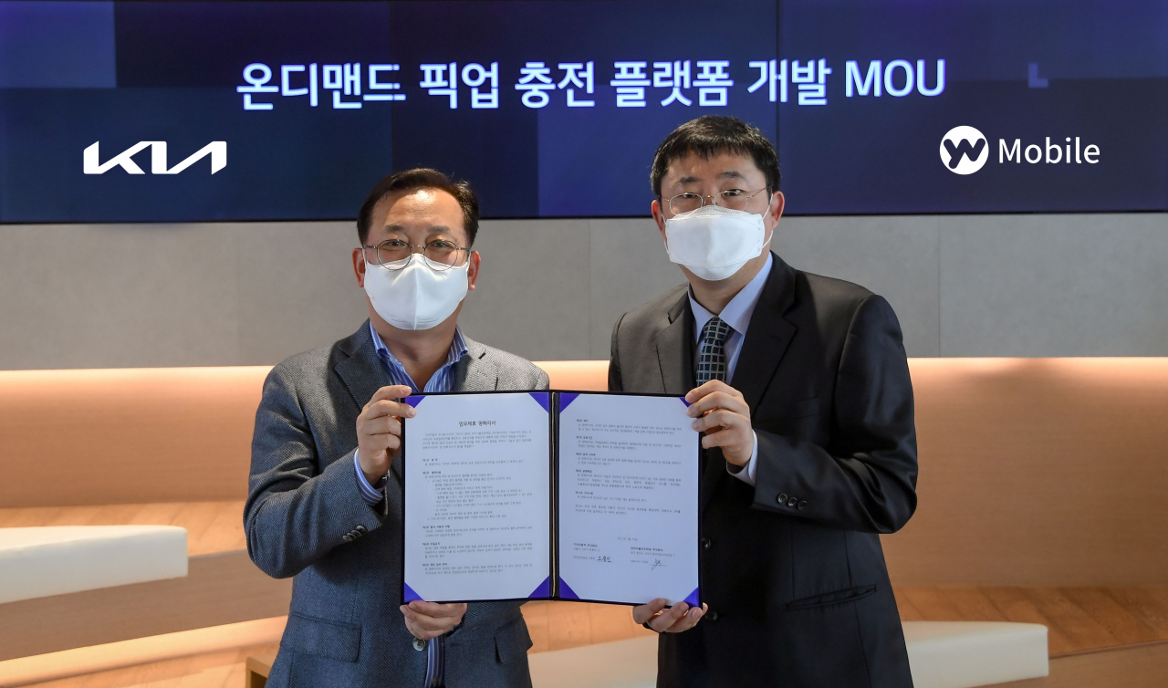 기아 판촉전략실장 오용진 상무과 YW모바일 이영석 대표이사가 기아 압구정 사옥 ‘BEAT360(서울시 강남구 소재)’에서 ‘온디맨드 픽업 충전 플랫폼 공동 개발을 위한 업무협약’을 체결한 후 기념 촬영을 하고 있다. [기아 제공]