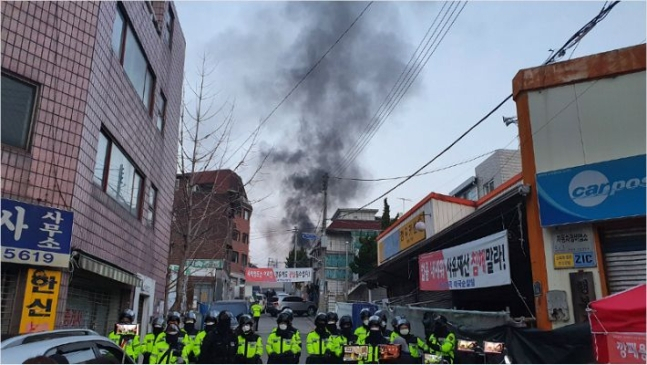 지난해 11월 26일 새벽 서울 성북구 장위동 사랑제일교회에 대한 명도집행이 시작된 가운데 이 교회 관계자들이 화염병을 던지며 반발해 검은 연기가 치솟고 있다. [연합]