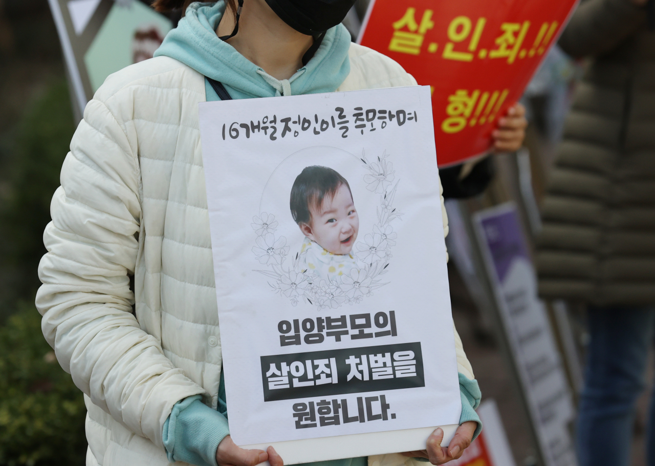16개월 된 입양 딸 정인이를 학대해 숨지게 한 혐의를 받는 양부모의 공판이 열린 지난 17일 오후 서울 양천구 서울남부지법 앞에서 시민들이 양부모에 대한 강력한 처벌을 요구하며 팻말 시위를 벌이고 있다. [연합]