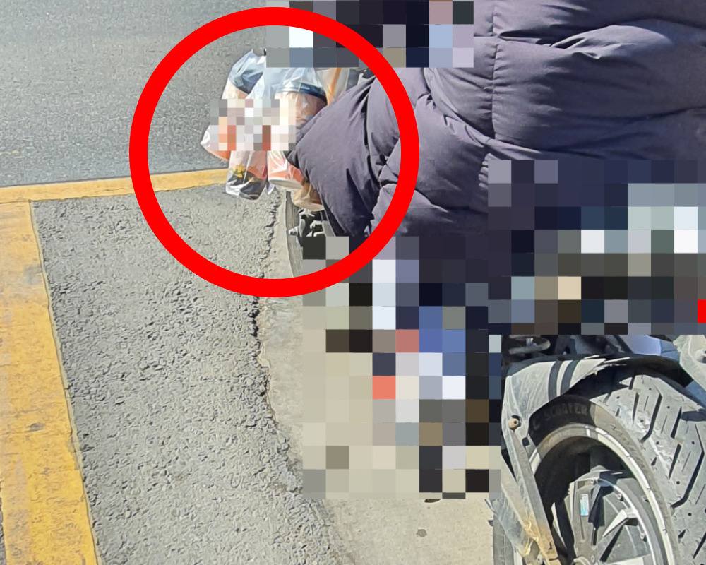배달업자로 추정되는 한 시민이 커피를 별도의 보온가방 없이 오토바이 손잡이에 걸어놓은 채 배달에 나서고 있다.[온라인 커뮤니티 갈무리]