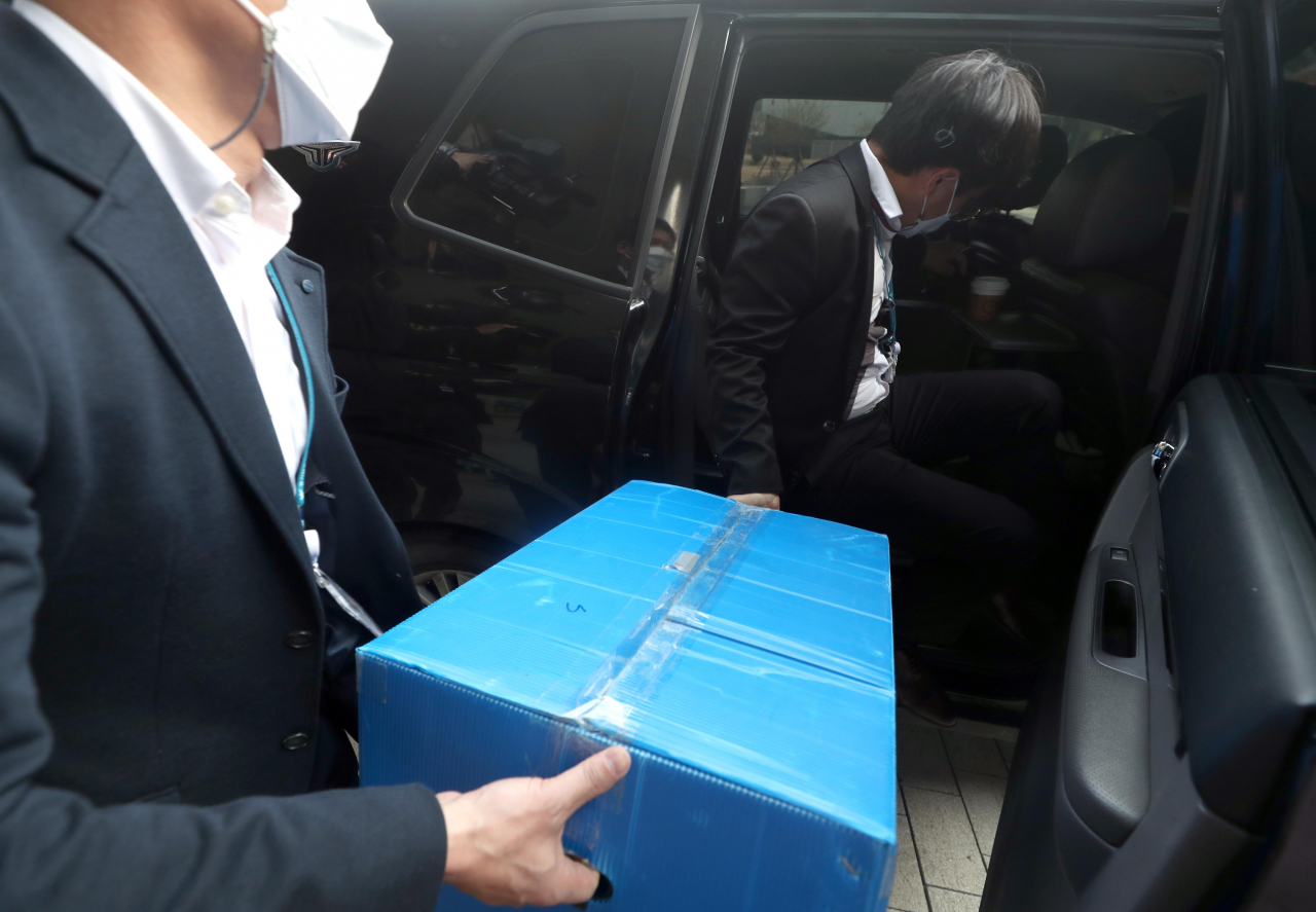 경찰이 17일 오후 경남 진주시 한국토지주택공사 (LH) 본사에서 압수품을 차량에 옮기고 있다. LH 직원들의 경기 광명·시흥 신도시 투기 의혹을 수사 중인 경찰은 이날 LH 본사, 국토교통부 등 6곳을 압수수색했다. 연합뉴스