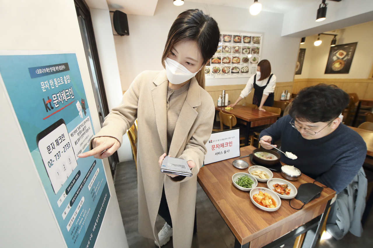식당 고객들이 매장 입장을 위해 ‘문자체크인’ 서비스로 출입 등록을 하고 있다. [KT 제공]