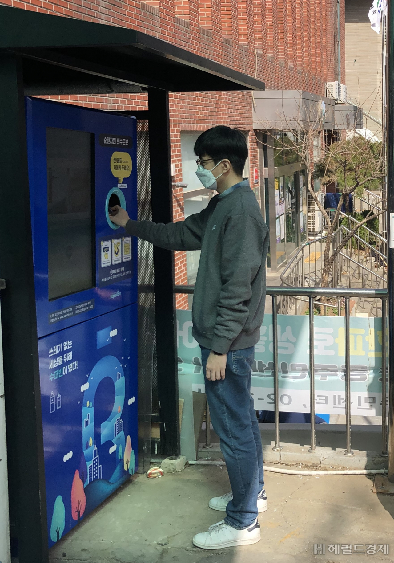 한 주민이 낙성대동주민센터 앞에서 스마트 재활용 수거함에 빈 페트병을 버리고 있다. [관악구 제공]