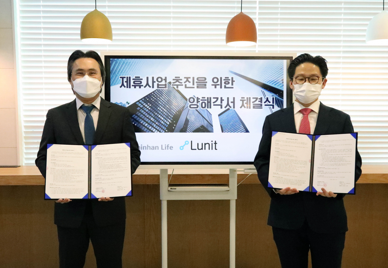 최승환(왼쪽) 신한생명 디지털전략책임자은 서울 중구 신한생명 본점에서 의료 인공지능 기업인 루닛과 헬스케어 사업 추진을 위한 업무제휴 협약식을 갖고 기념촬영을 하고 있다. 오른쪽은 서범석 루닛 대표이사. [신한생명 제공]