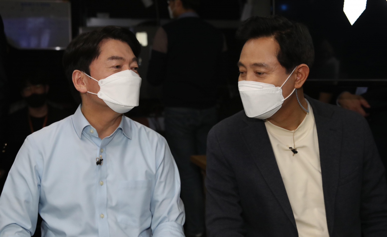 국민의힘 오세훈 서울시장 후보와 국민의당 안철수 서울시장 후보가 15일 서울 영등포 더플러스 스튜디오에서 열린 단일화 비전발표회에 앞서 대화하고 있다. [연합]