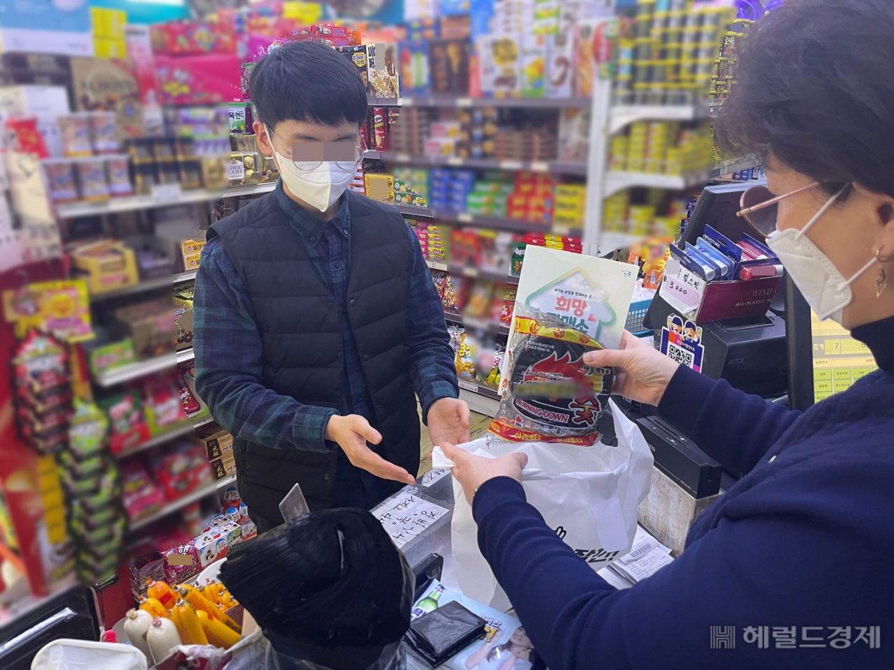 번개탄 희망판매소에서 번개탄과 함께 생명을 지키는 문구가 적힌 봉투를 건네고 있다. [강북구 제공]