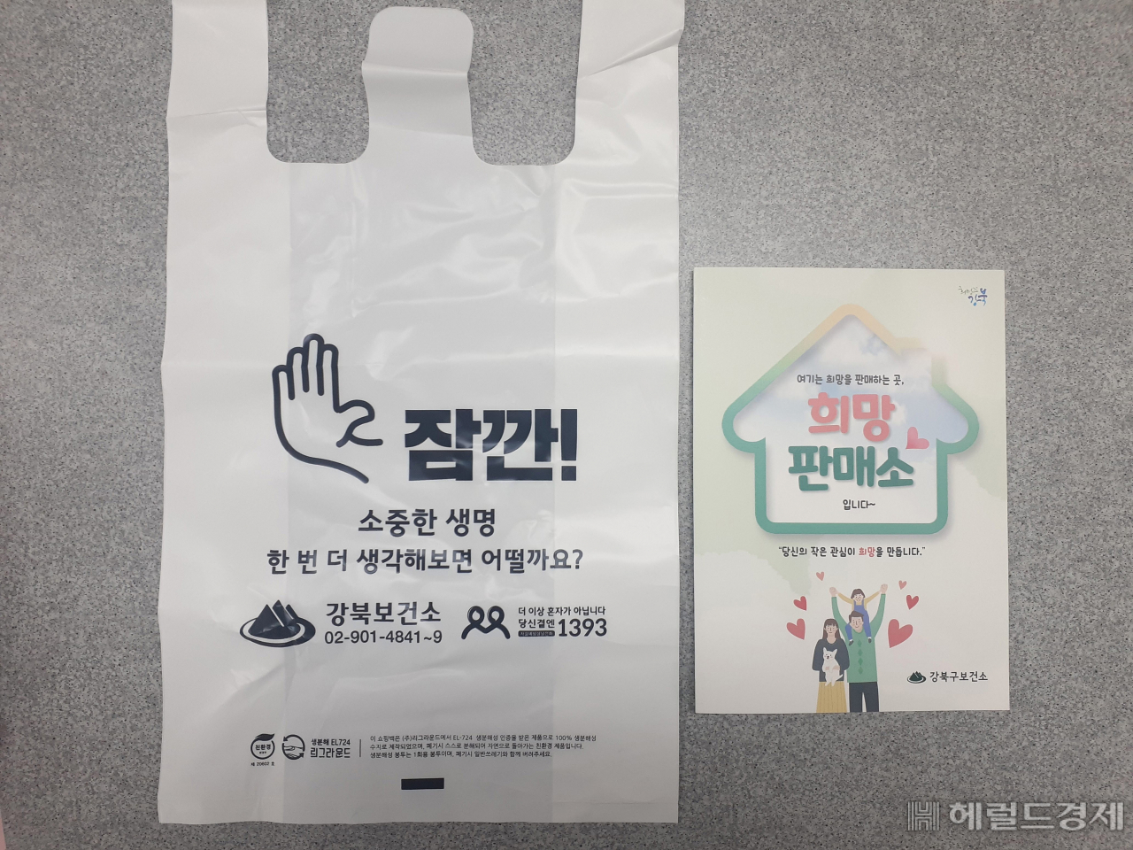 번개탄 희망판매소에서 번개탄과 함께 생명을 지키는 문구가 적힌 봉투를 건네고 있다. [강북구 제공]
