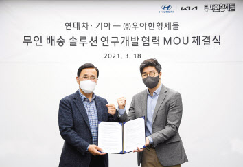 18일 현대차 박정국(왼쪽) 연구개발본부부본부장과 우아한형제들 오세윤 최고전략책임자(CSO)가 ‘무인배송 솔루션 연구개발 협력 MOU’를 체결하고 기념 사진을 찍고 있다. [현대차·기아 제공]