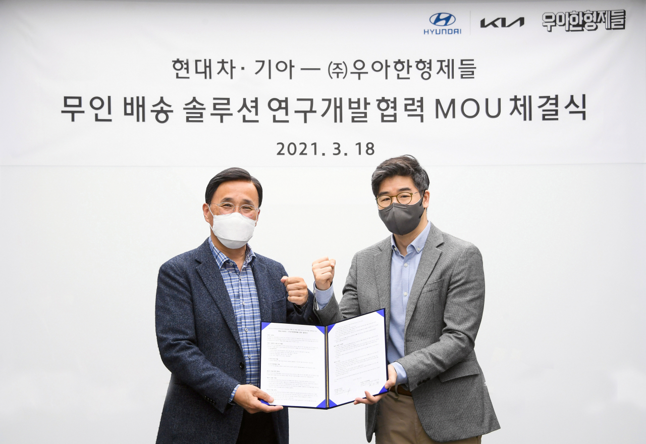18일 현대차·기아 남양연구소에서 현대차 박정국 연구개발본부부본부장(왼쪽)과 우아한형제들 오세윤 최고전략책임자(CSO)가 '무인배송 솔루션 연구개발 협력 MOU'를 체결하고 기념 사진을 찍고 있다. [현대차·기아 제공]