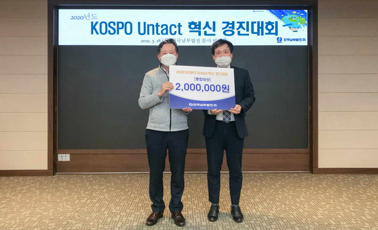 한국남부발전 장석식 기획처장(왼쪽)이 종합 대상을 받은 과제 대표자와 기념촬영을 하고 있다. [남부발전 제공]