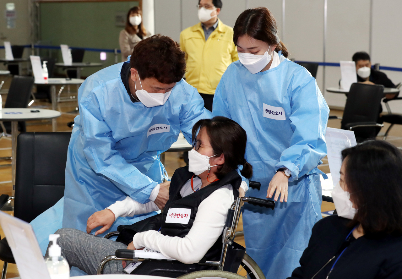 19일 오전 인천시 연수구 선학체육관에 마련된 코로나19 지역예방접종센터에서 열린 모의훈련에서 센터 관계자들이 백신 이상반응을 보이는 접종자 발생 상황에 대처하는 훈련을 하고 있다. [연합]