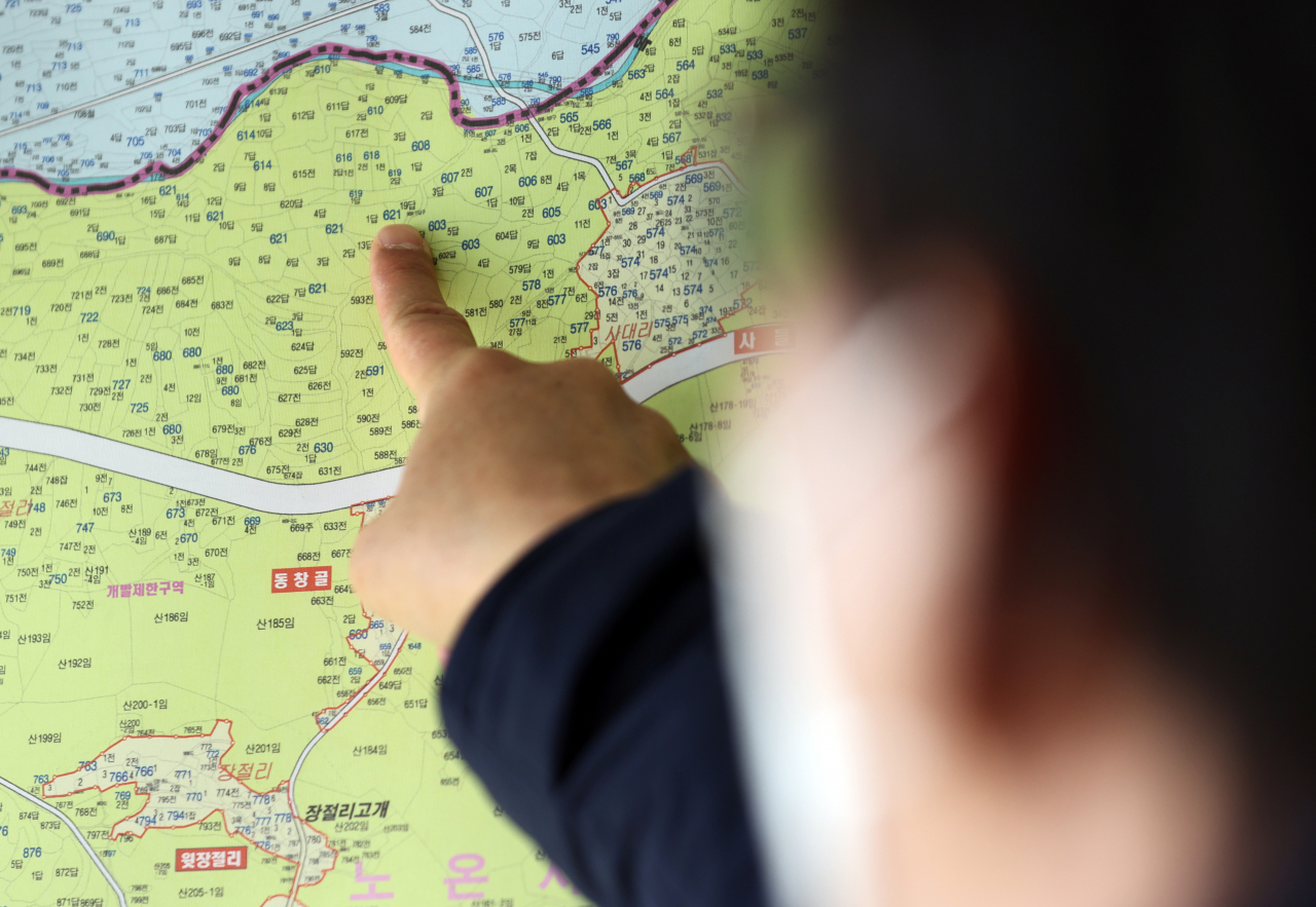 경기 광명시 노온사동의 한 부동산 관계자가 시 소속 공무원이 매입한 노온사동의 토지 일대를 가리키고 있다. [연합뉴스]