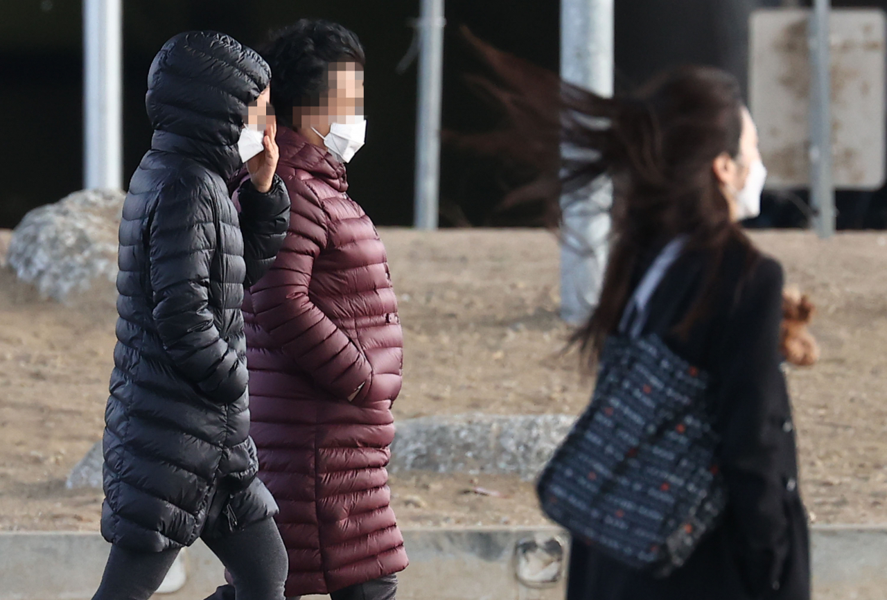 강풍이 불며 다소 쌀쌀한 날씨를 보인 지난 21일 오후 서울 서초구 반포한강공원에서 시민들이 패딩 등 두툼한 외투를 입고 산책하고 있다. [연합]