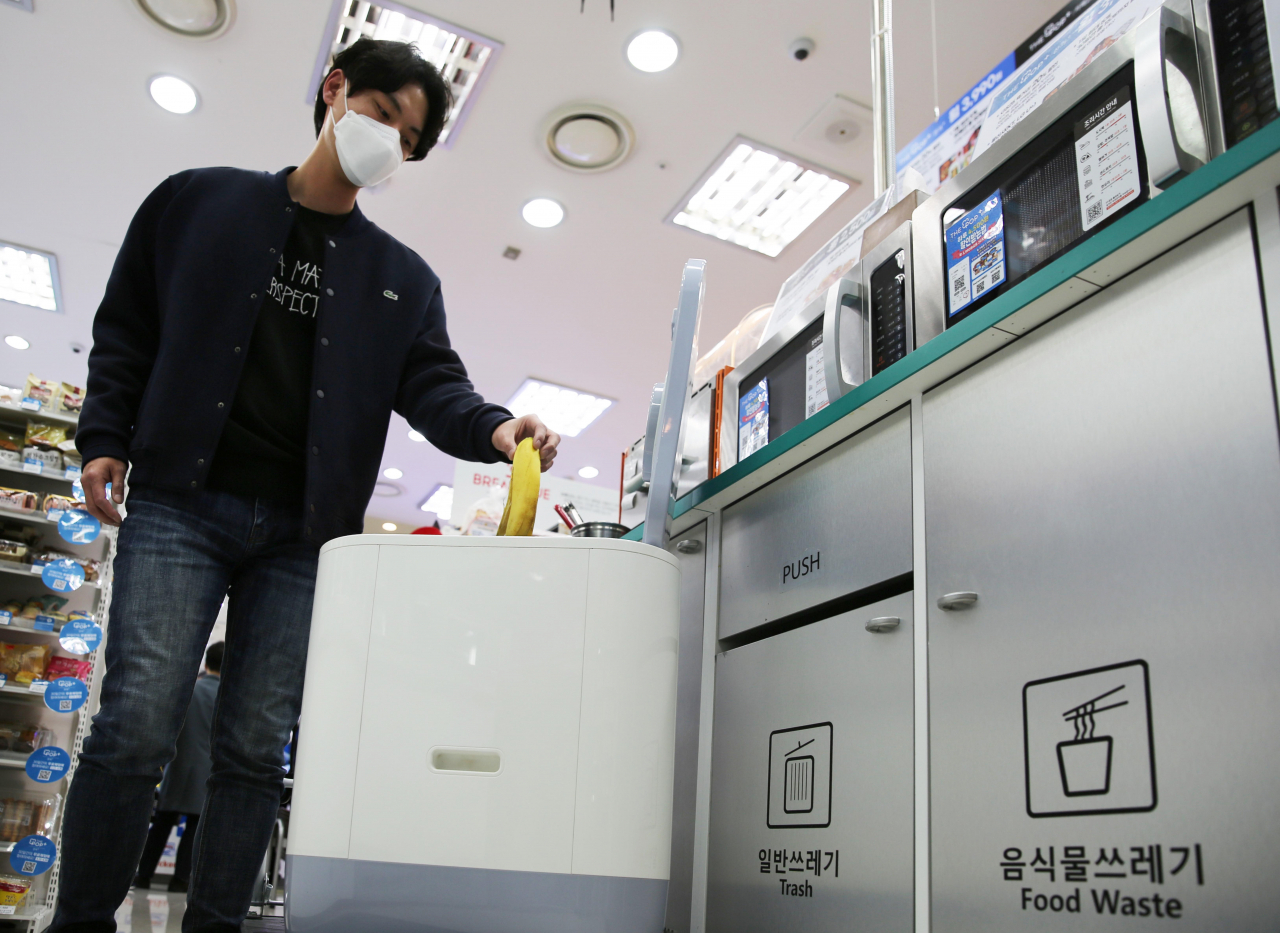 GS25에서 소멸식 음식물 처리기에 음식물 쓰레기를 버리는 모습.[GS25 제공]
