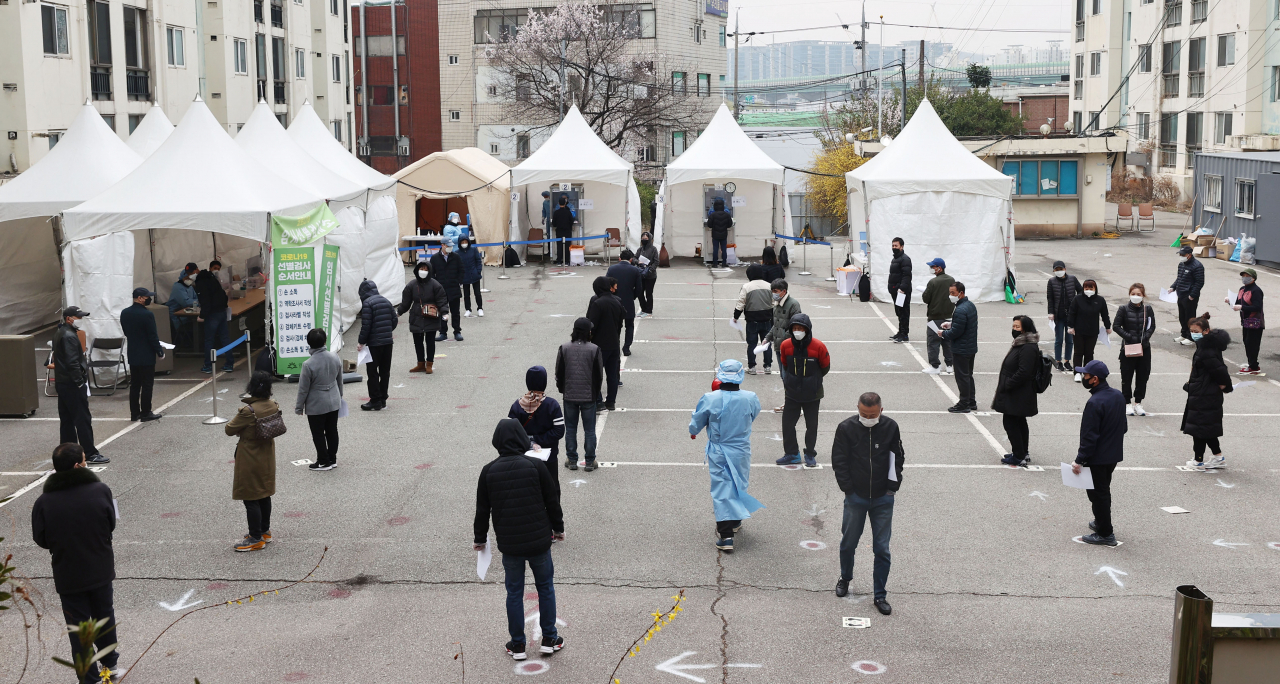 신종 코로나바이러스 감염증(코로나19) 신규 확진자가 닷새 연속 400명대를 기록한 21일 오전 서울 금천구청 앞에 마련된 외국인 임시선별검사소에서 외국인들이 검체 검사를 받기 위해 줄을 서 있다. [연합]